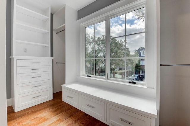 walk in closet with light hardwood / wood-style floors