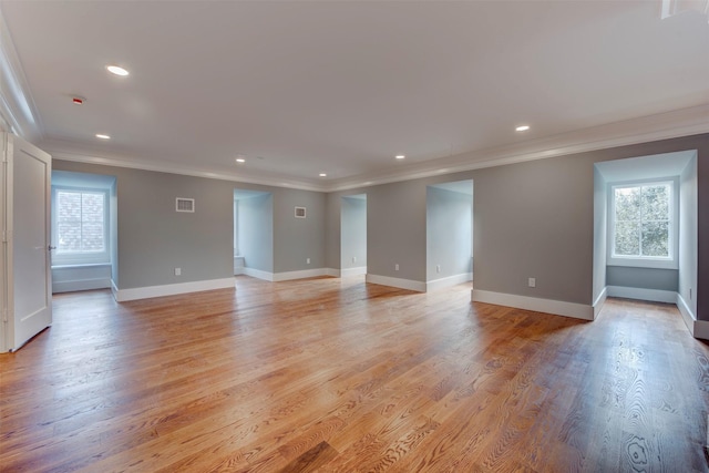 unfurnished room featuring crown molding and plenty of natural light