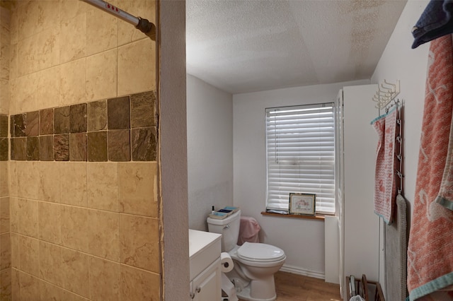 bathroom featuring vanity, walk in shower, wood-type flooring, a textured ceiling, and toilet