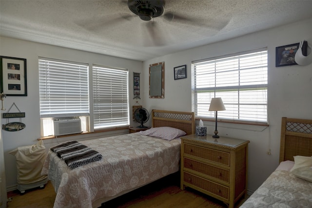 bedroom with ceiling fan, a textured ceiling, and dark hardwood / wood-style floors