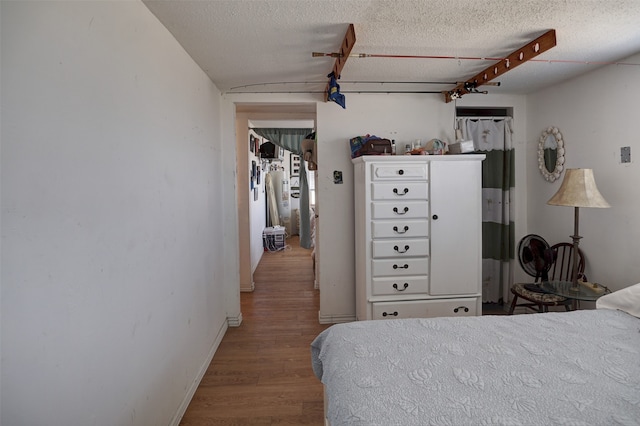 bedroom with a textured ceiling and light wood-type flooring