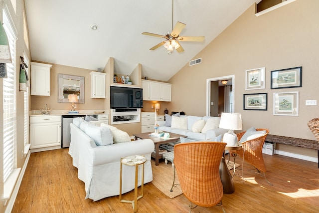 living room featuring light wood-type flooring, ceiling fan, and high vaulted ceiling