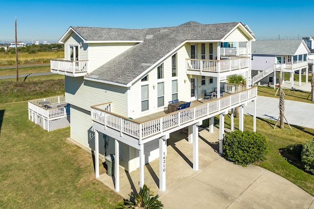 rear view of house with a balcony and a lawn