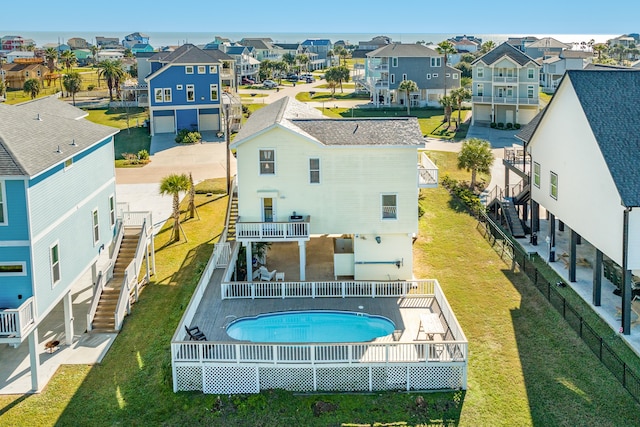 back of house with a lawn and a fenced in pool