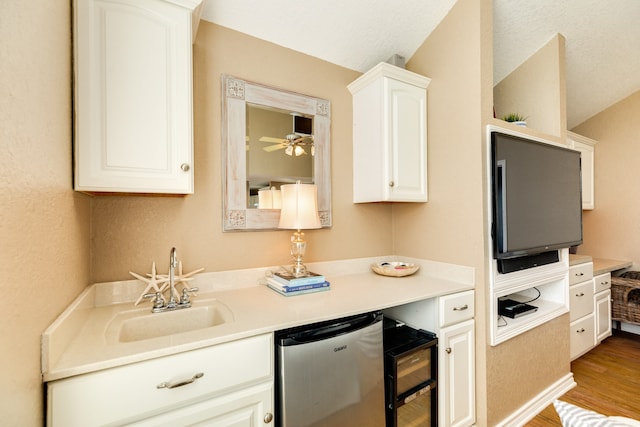 kitchen with light hardwood / wood-style floors, sink, white cabinetry, ceiling fan, and stainless steel dishwasher