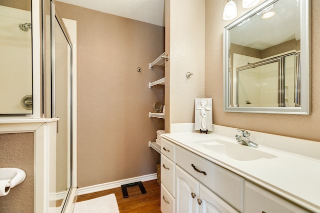 bathroom featuring a textured ceiling, vanity, hardwood / wood-style floors, and an enclosed shower