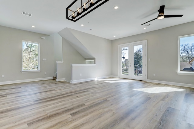 unfurnished living room featuring french doors, light wood-type flooring, ceiling fan, and a healthy amount of sunlight