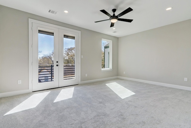 carpeted spare room with ceiling fan and french doors