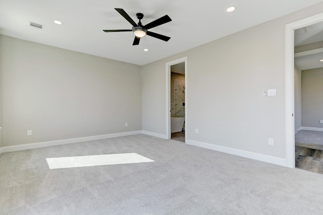 unfurnished bedroom featuring ceiling fan, a spacious closet, ensuite bathroom, light carpet, and a closet