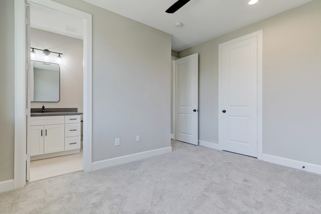 unfurnished bedroom with connected bathroom, ceiling fan, sink, and light colored carpet