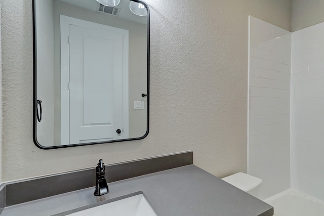 bathroom featuring vanity and a shower