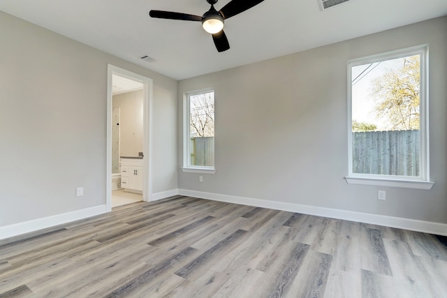 empty room with ceiling fan and light hardwood / wood-style flooring