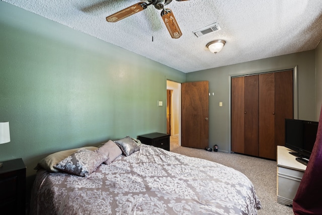 bedroom with carpet flooring, a textured ceiling, ceiling fan, and a closet