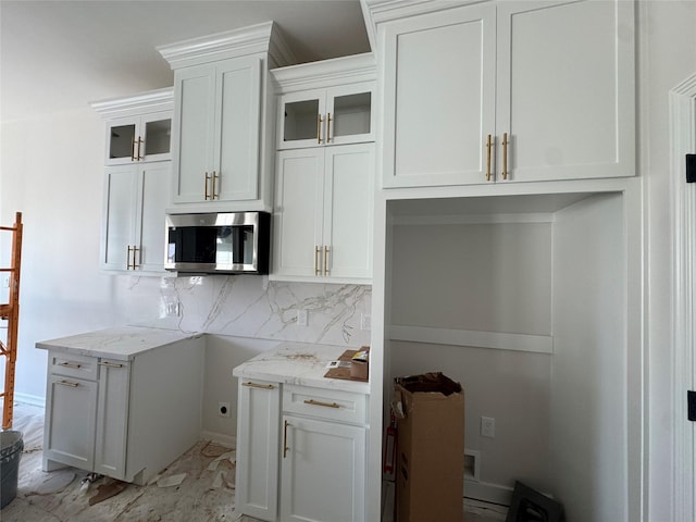 kitchen featuring decorative backsplash, white cabinetry, and light stone counters