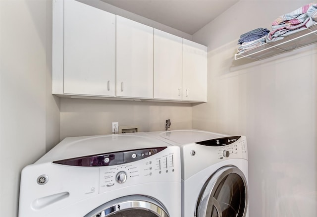 laundry room featuring washer and dryer and cabinets