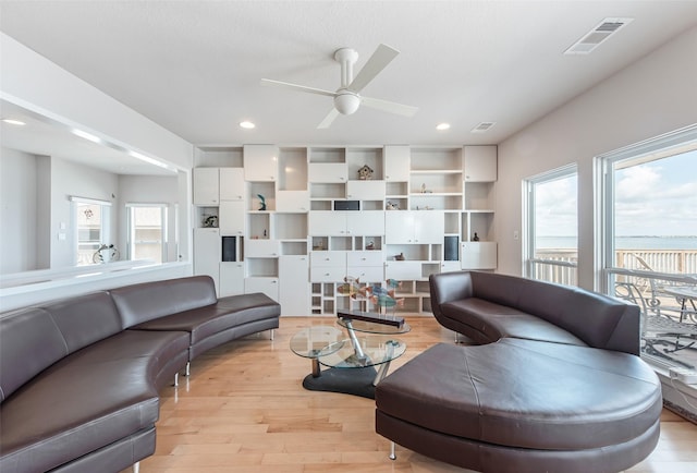 living room featuring ceiling fan and light hardwood / wood-style floors