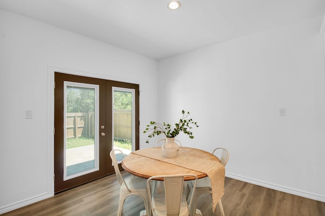 dining area with hardwood / wood-style floors and french doors