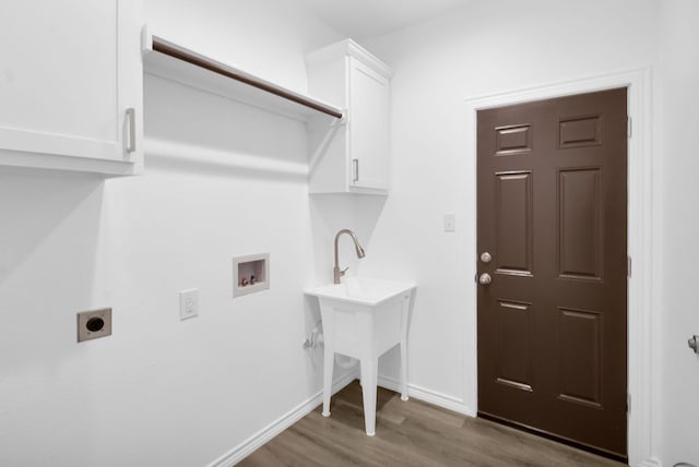 clothes washing area featuring dark hardwood / wood-style flooring, washer hookup, cabinets, and electric dryer hookup