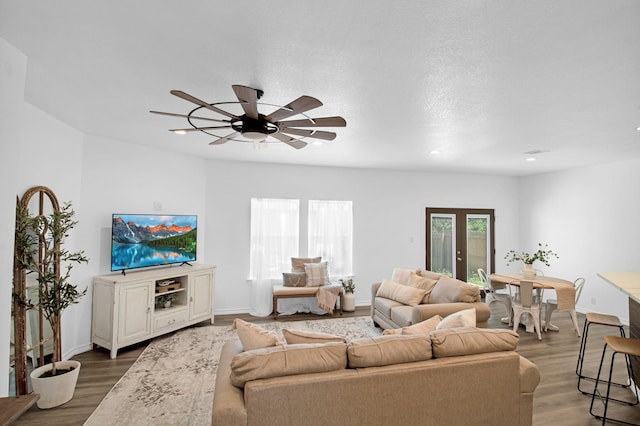 living room featuring ceiling fan, french doors, dark hardwood / wood-style flooring, and a healthy amount of sunlight