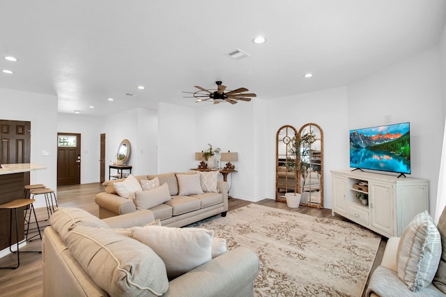 living room featuring ceiling fan and light hardwood / wood-style flooring