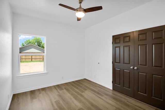 unfurnished bedroom featuring ceiling fan, light hardwood / wood-style flooring, and a closet