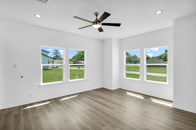 spare room with ceiling fan, hardwood / wood-style flooring, and plenty of natural light