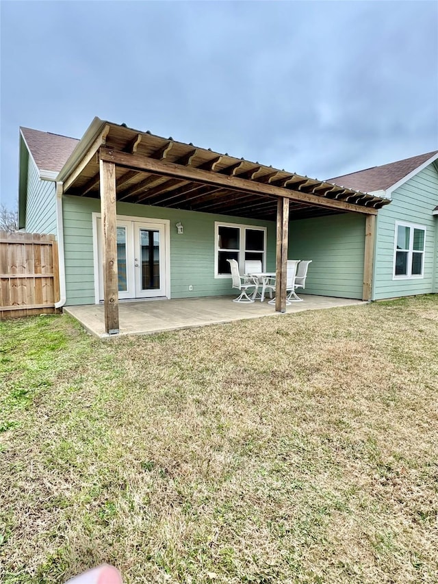 rear view of property featuring a patio, french doors, and a lawn