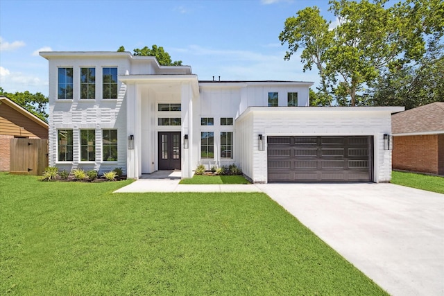 view of front of home featuring a front lawn, a garage, and french doors