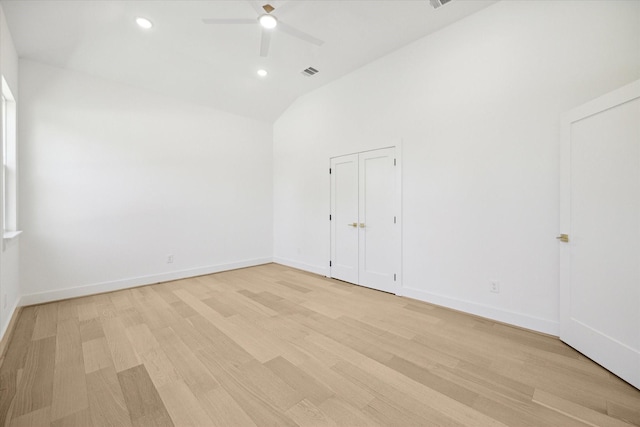 empty room featuring ceiling fan, vaulted ceiling, and light hardwood / wood-style flooring