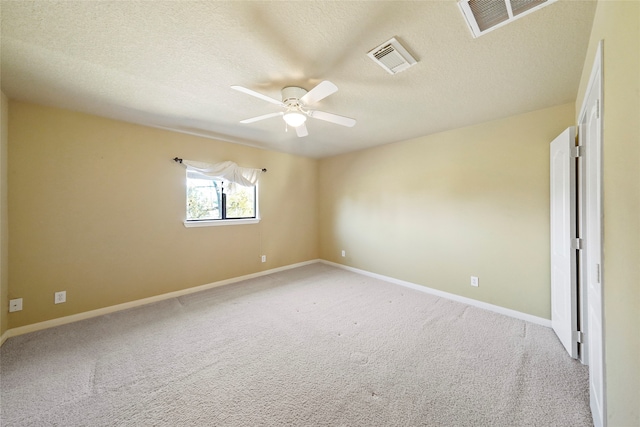 carpeted empty room featuring ceiling fan and a textured ceiling