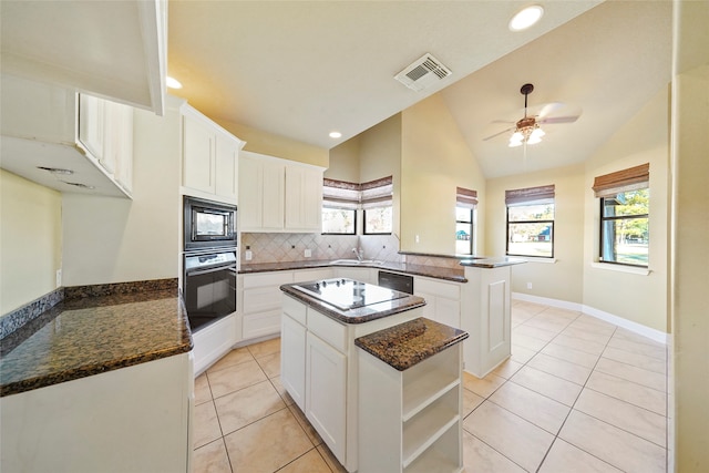 kitchen featuring black appliances, kitchen peninsula, a center island, and white cabinets