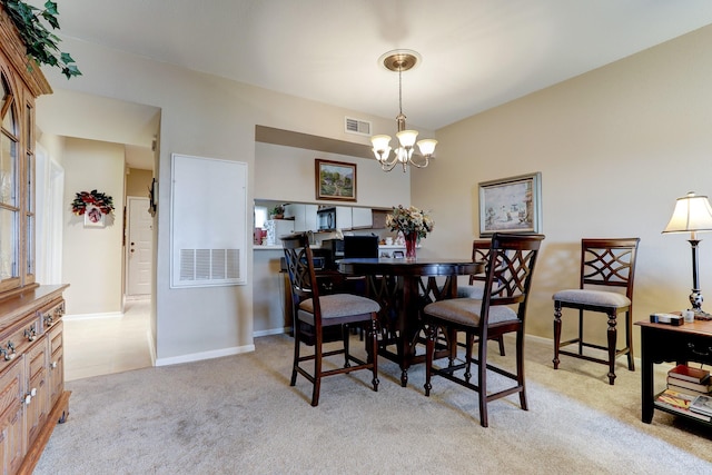 carpeted dining room featuring a notable chandelier