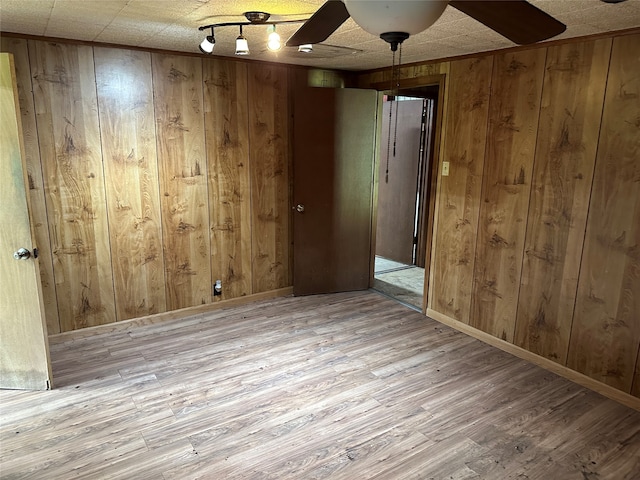 empty room with hardwood / wood-style floors and wood walls