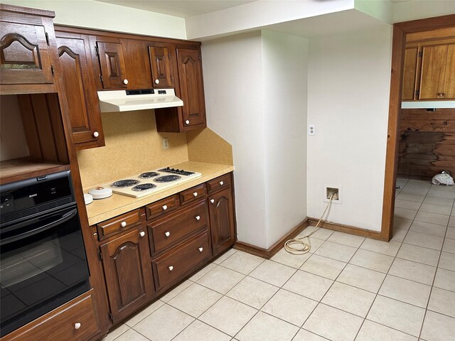 kitchen featuring light tile patterned floors, black oven, and white electric stovetop