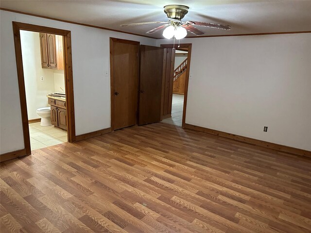 unfurnished bedroom with crown molding, ceiling fan, connected bathroom, and light hardwood / wood-style floors