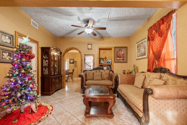 tiled living room with a textured ceiling and ceiling fan