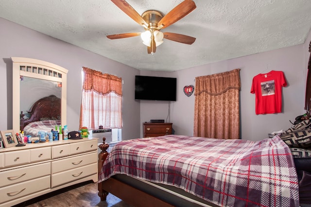 bedroom featuring a textured ceiling, ceiling fan, and wood-type flooring