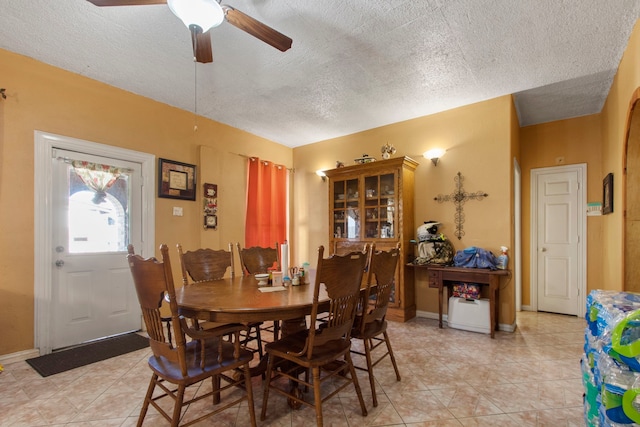 dining area featuring light tile patterned flooring, a textured ceiling, and ceiling fan