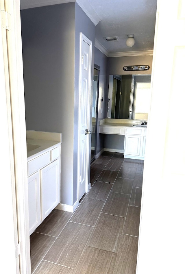 bathroom featuring tile patterned floors, crown molding, and vanity