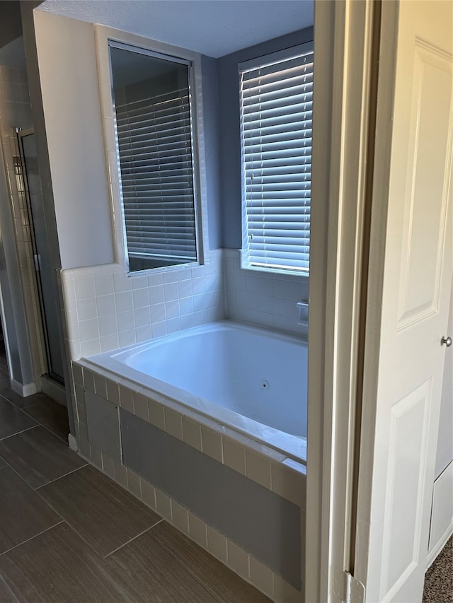 bathroom with tile patterned floors and a relaxing tiled tub