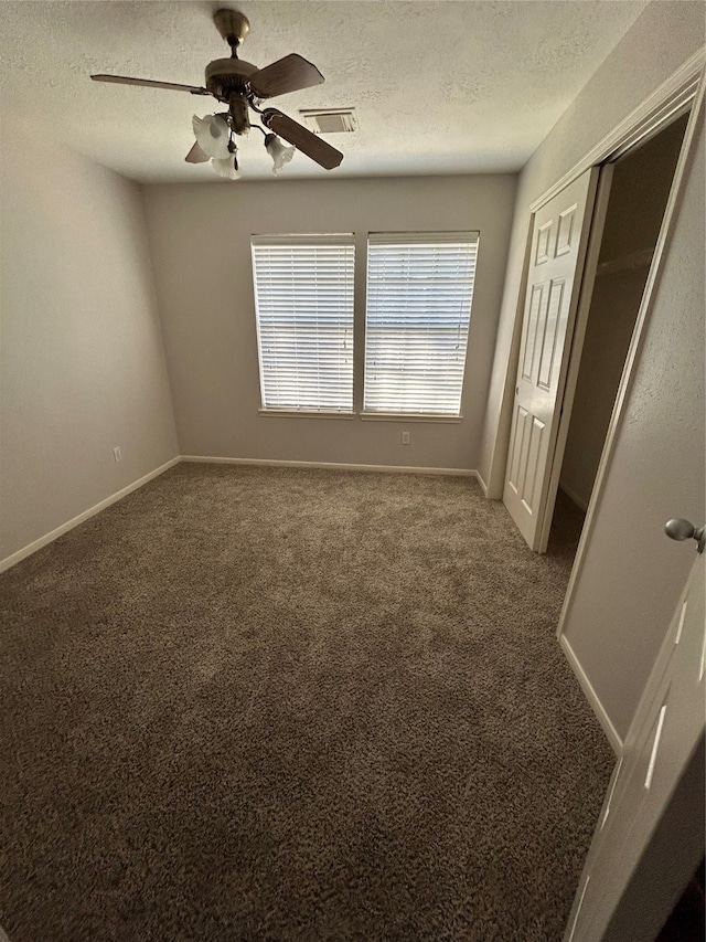 unfurnished bedroom featuring a textured ceiling, carpet, ceiling fan, and a closet