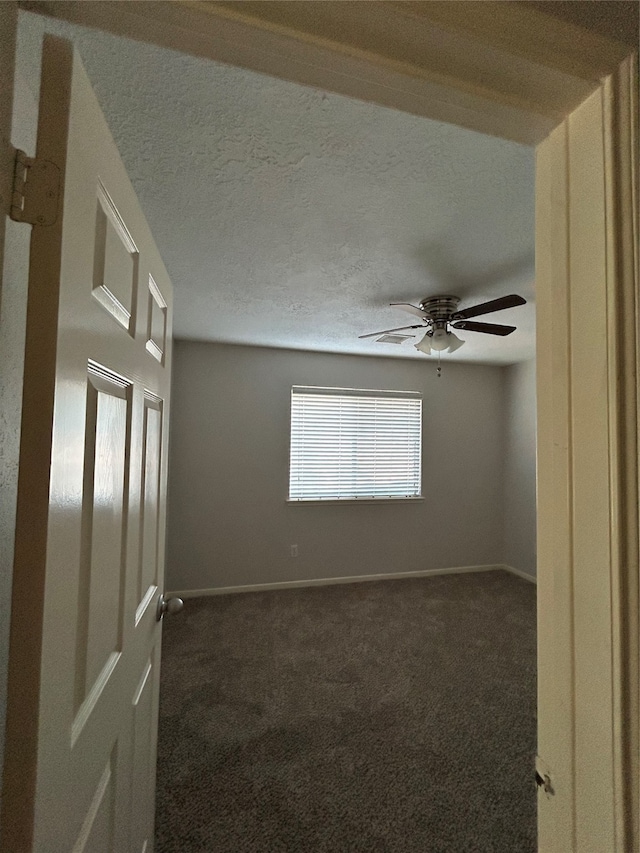 carpeted spare room with a textured ceiling and ceiling fan