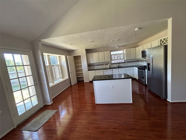 kitchen featuring appliances with stainless steel finishes, dark hardwood / wood-style flooring, sink, and a kitchen island