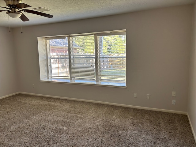 spare room with carpet, a textured ceiling, and ceiling fan