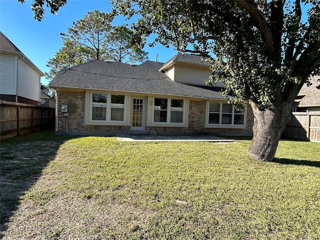 back of house with a patio and a lawn