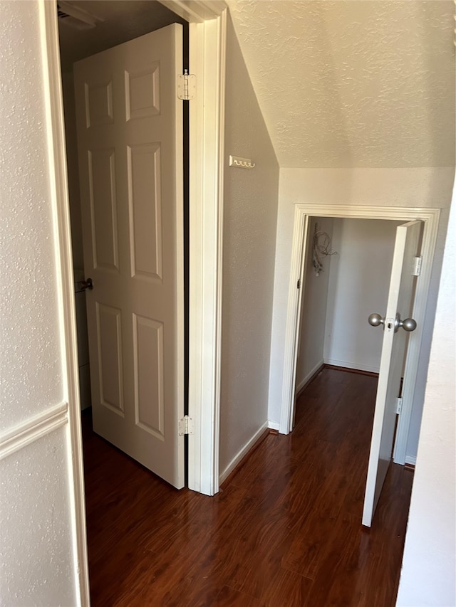 corridor featuring dark hardwood / wood-style floors and lofted ceiling