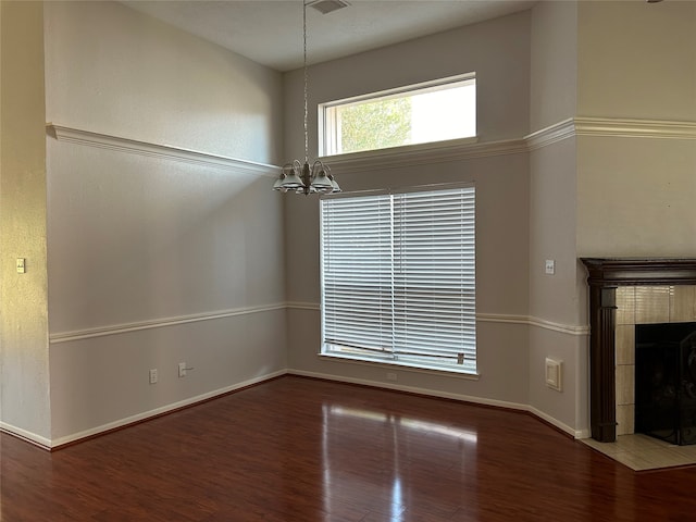 unfurnished living room featuring a chandelier and hardwood / wood-style floors