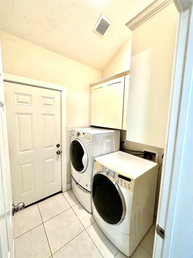 laundry area with light tile patterned floors, a textured ceiling, and washer and clothes dryer