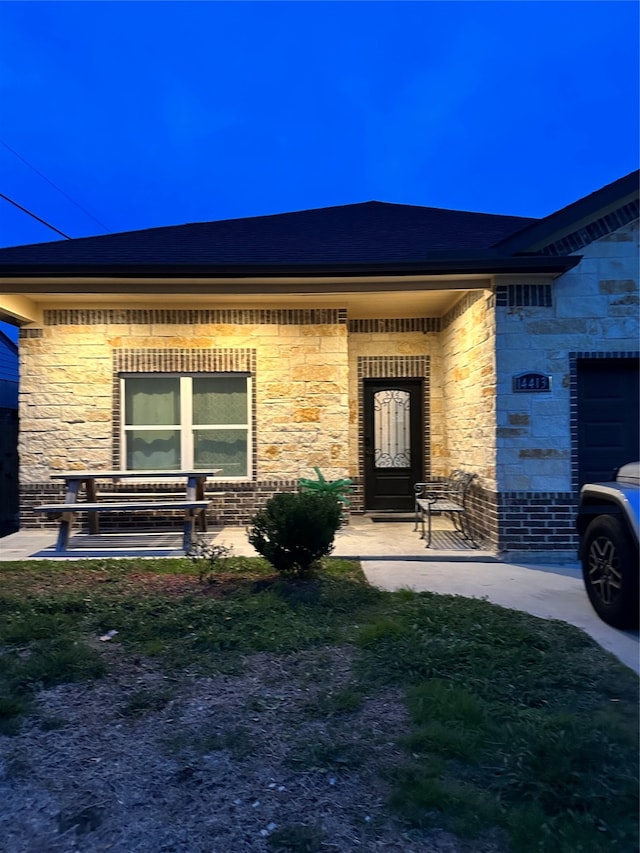 doorway to property featuring a lawn and a garage