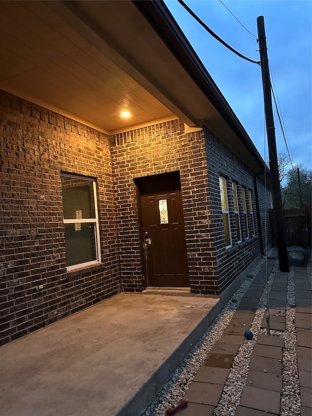 view of exterior entry featuring a patio